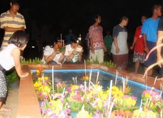 An evacuee couple prepares to loy (float) their krathongs in Sattahip, perhaps thinking of the final words to the Loy Krathong song, “As we push away we pray, we can see a better day.”